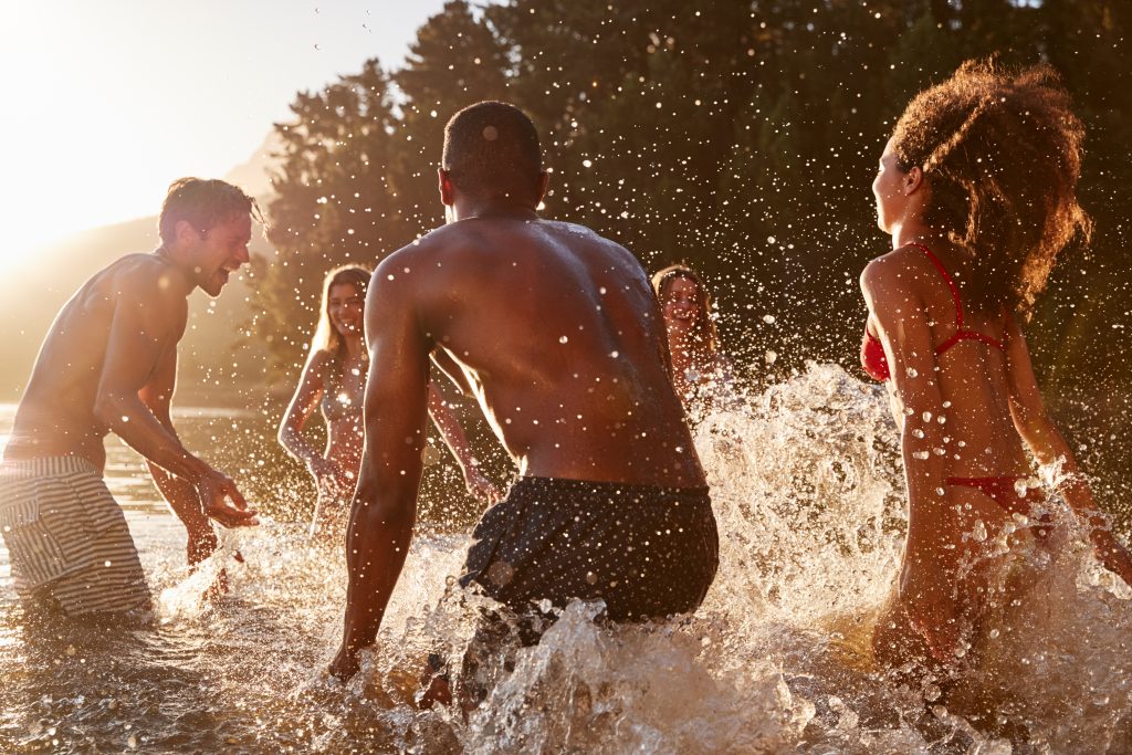 A group of socially distanced people swimming in fresh water as part of their summer bucket list